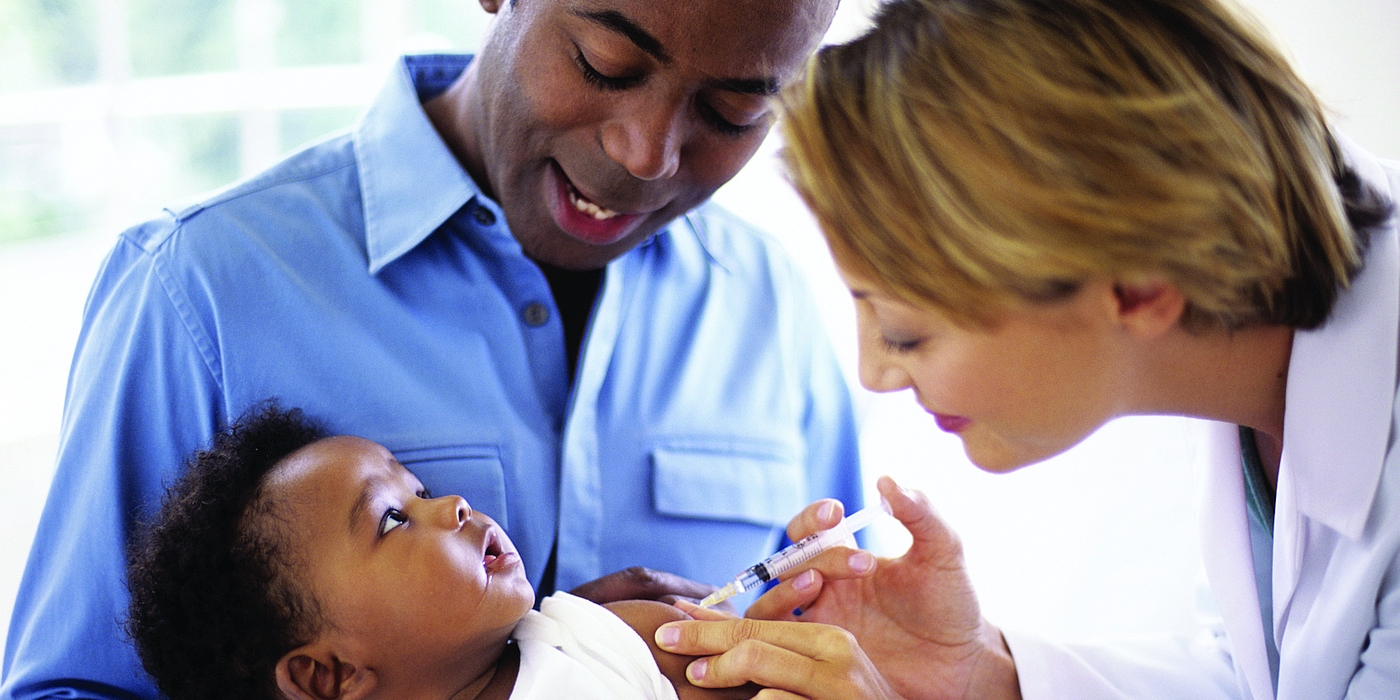 A doctor vaccinates a young child as a parent holds them.!''