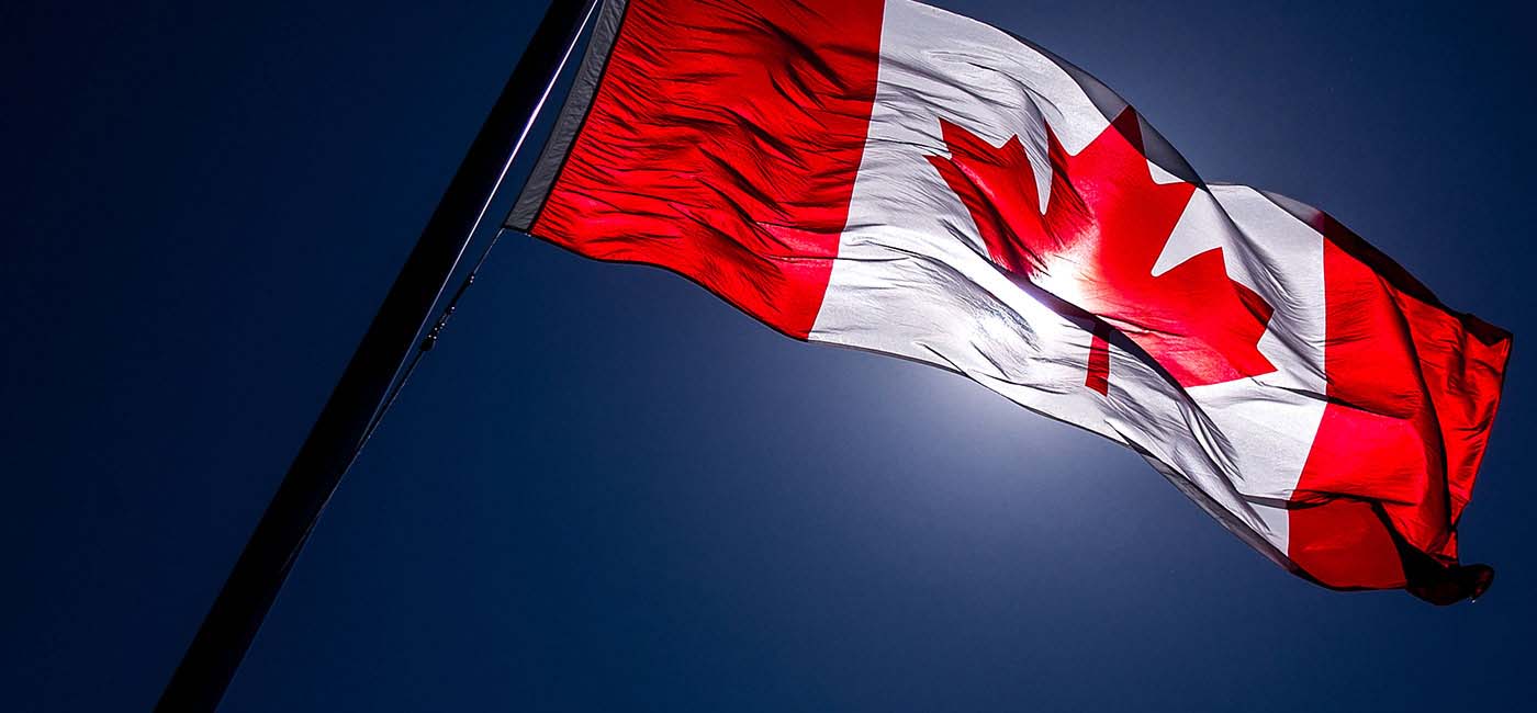 Canadian flag blows in the wind on a blue, sunny day